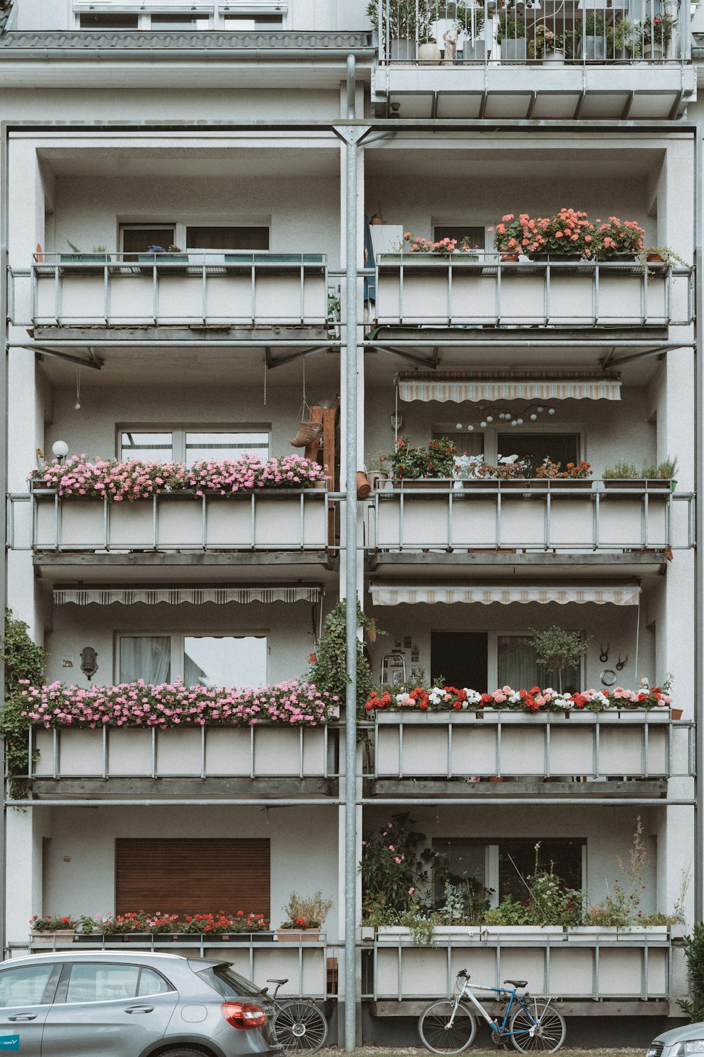 a tall building with a bunch of flowers on the balconies