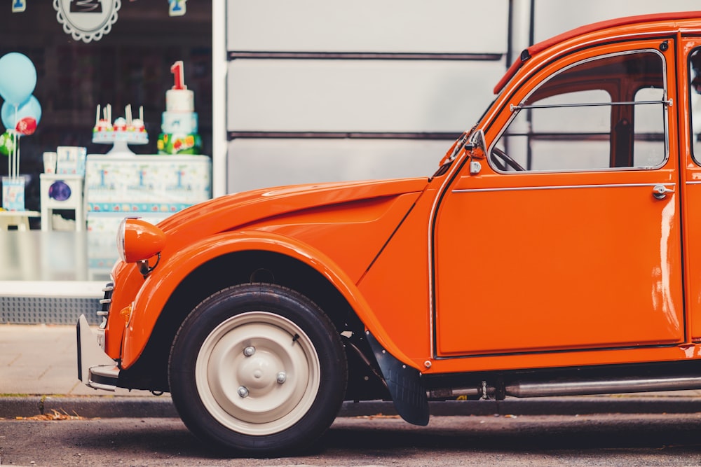 an orange car parked on the side of the road