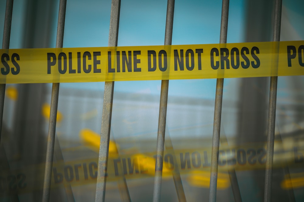 a close up of a yellow police line behind bars