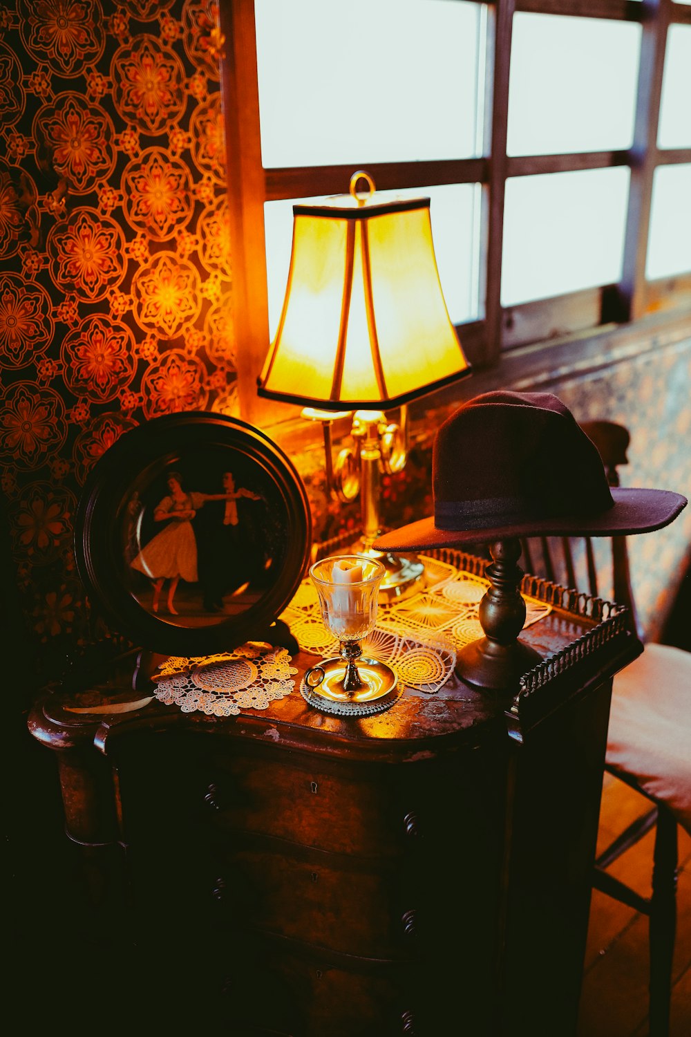 a table with a lamp and a chair in front of it