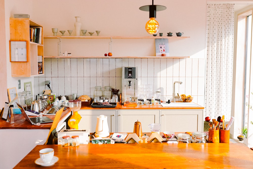 a kitchen filled with lots of clutter next to a window