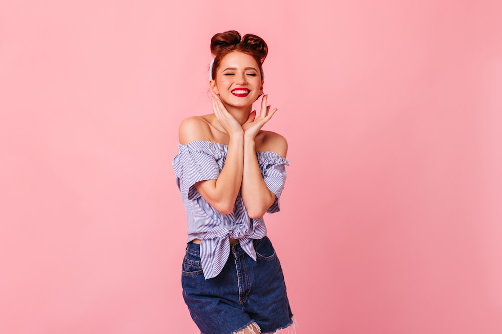 a woman posing with her hands folded in front of her face