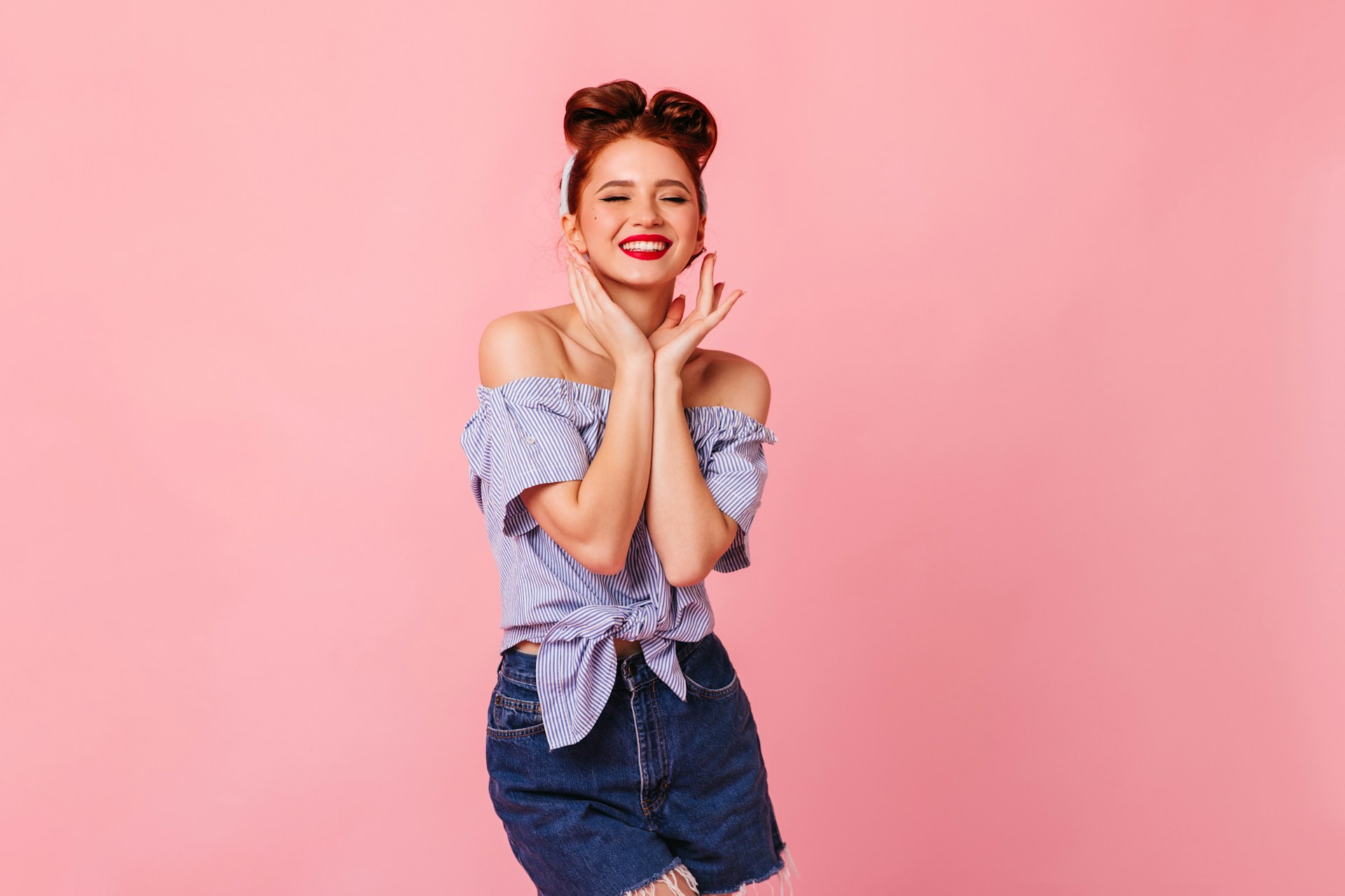 a woman posing with her hands folded in front of her face