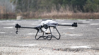 A black and white remote controlled flying device in a parking lot