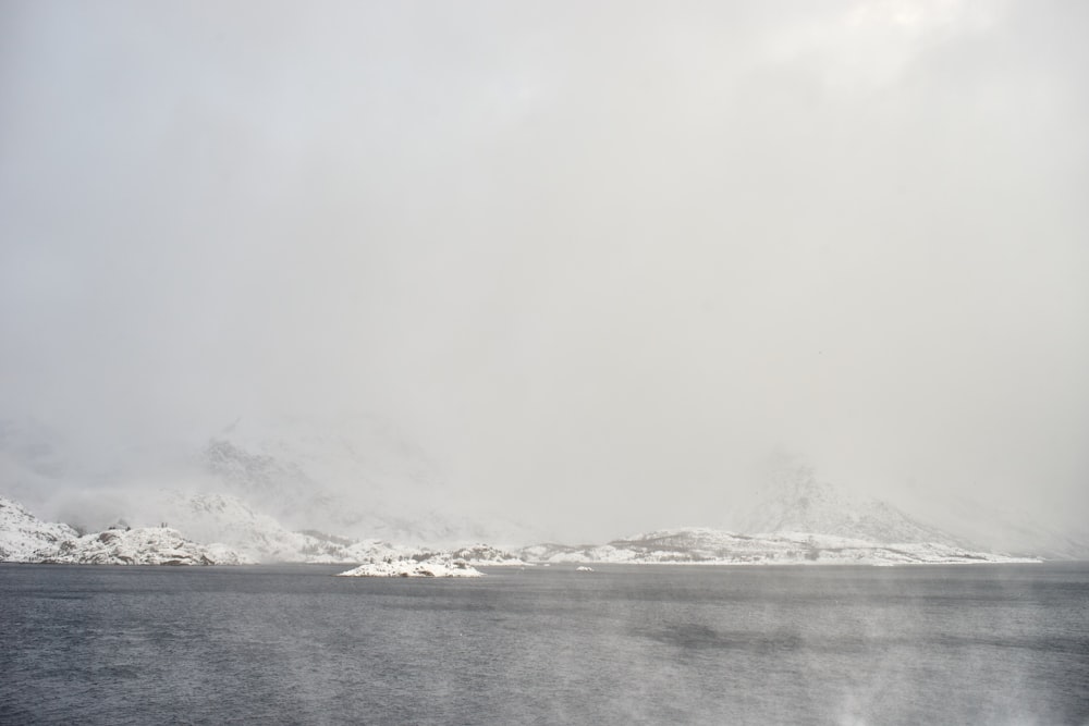 a large body of water surrounded by snow covered mountains