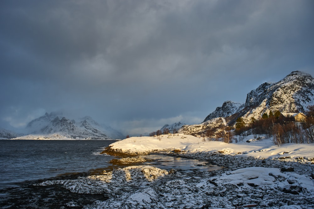 a snow covered shore with mountains in the background