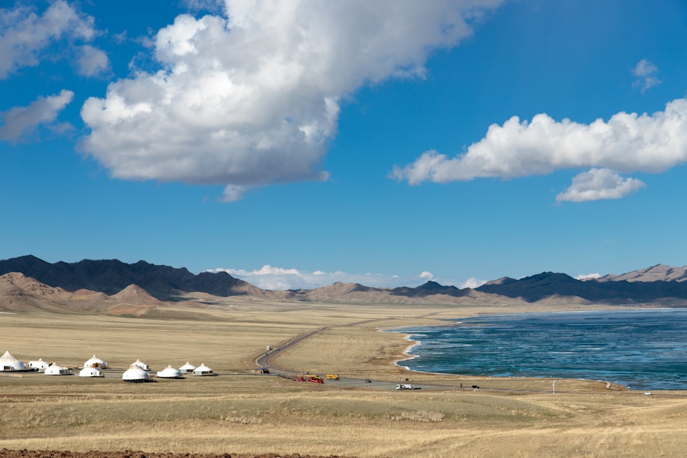 a group of tents sitting on top of a dry grass field