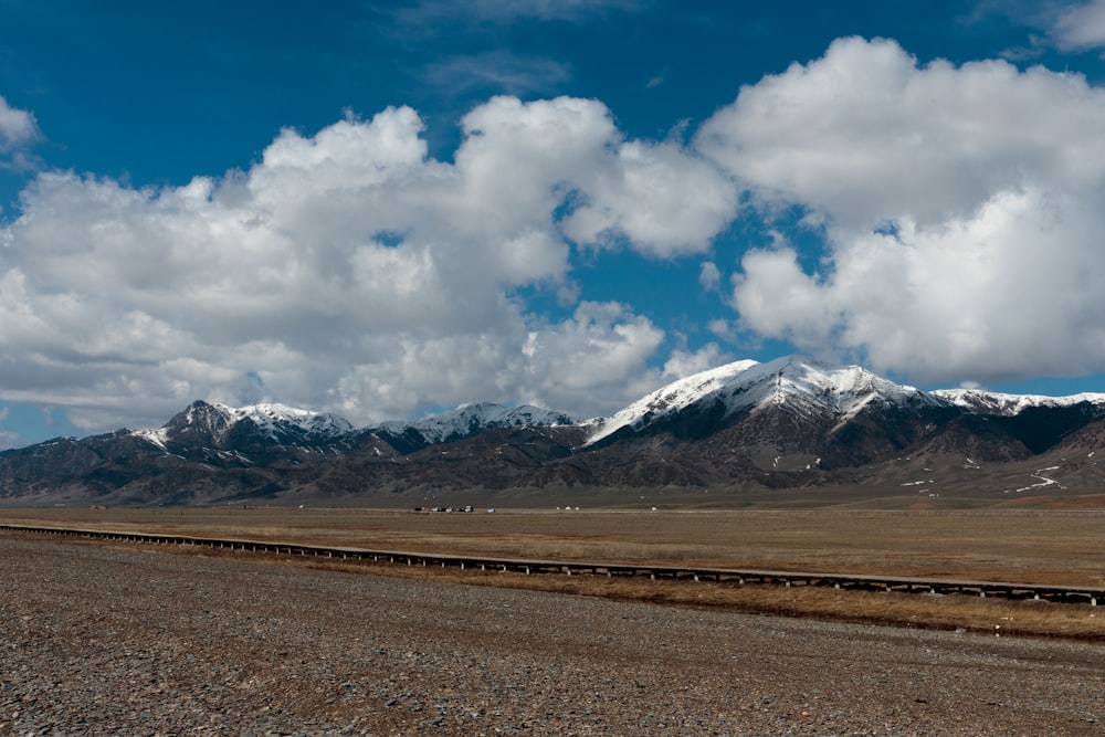 a train traveling through a desert under a cloudy sky