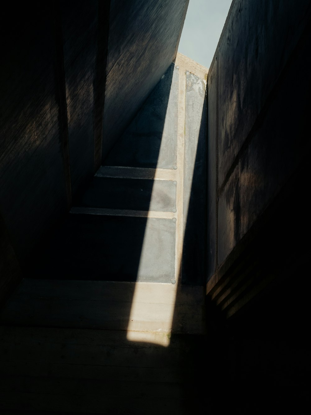 eine Treppe, die zu einem Oberlicht in einem dunklen Raum führt