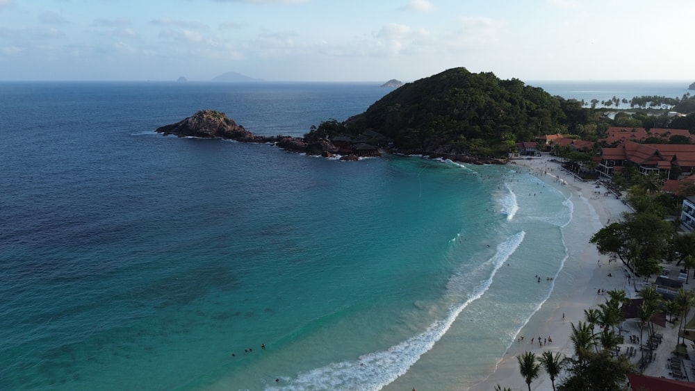 an aerial view of a beach with a mountain in the background