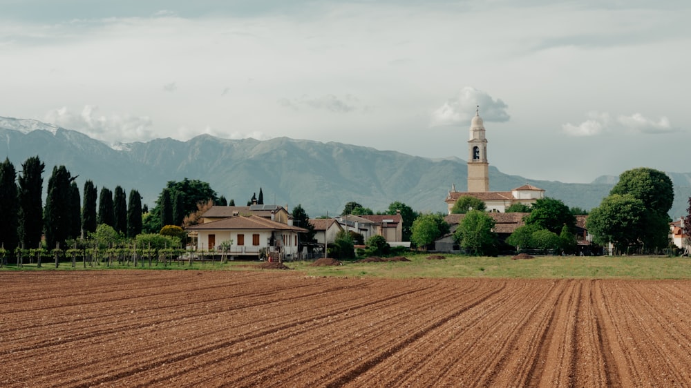 a large field with a church in the background