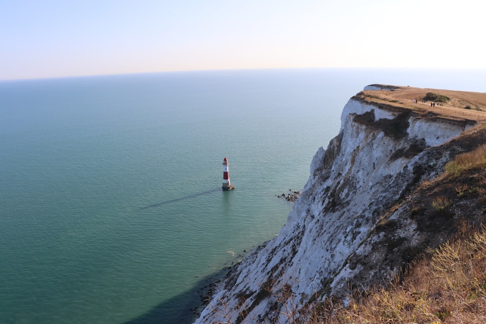 a lighthouse on the edge of a cliff overlooking the ocean