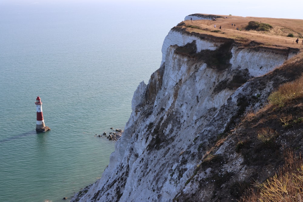 a lighthouse on the edge of a cliff overlooking the ocean