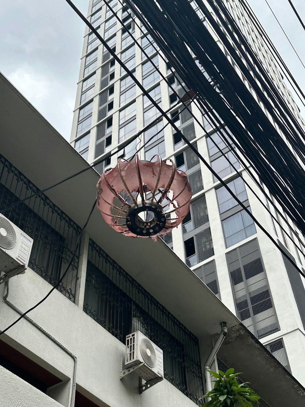 a pink umbrella hanging from the side of a building