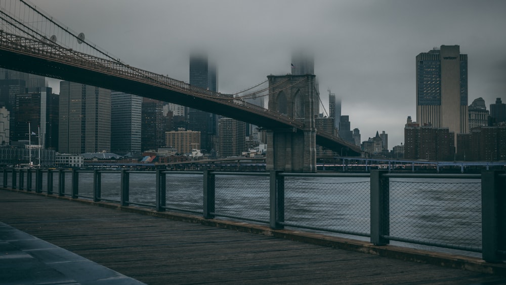 a bridge over a body of water with a city in the background