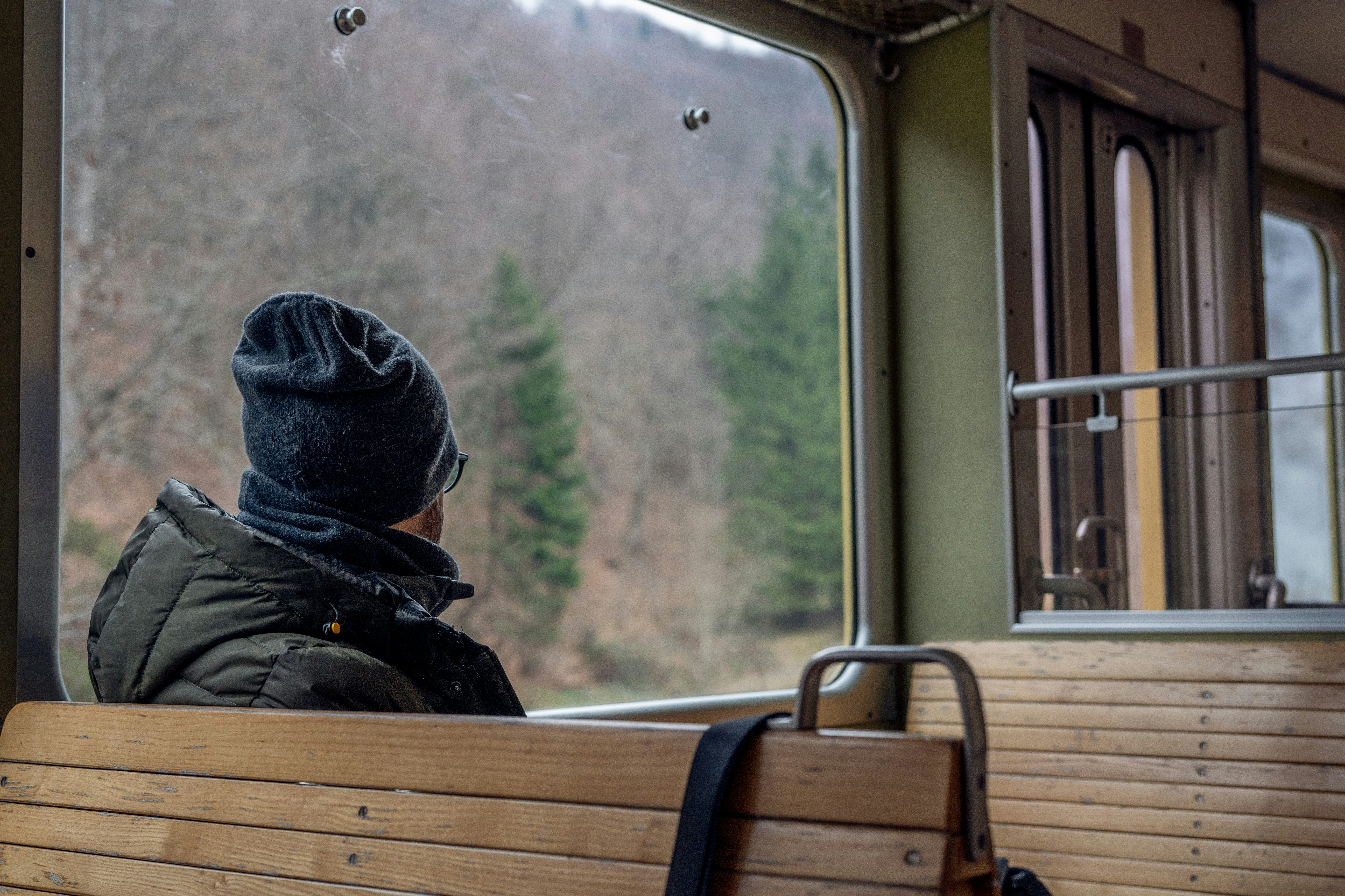 a person sitting on a bench looking out a window