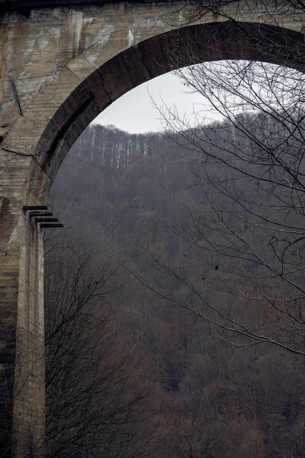 a stone arch with a clock on the side of it