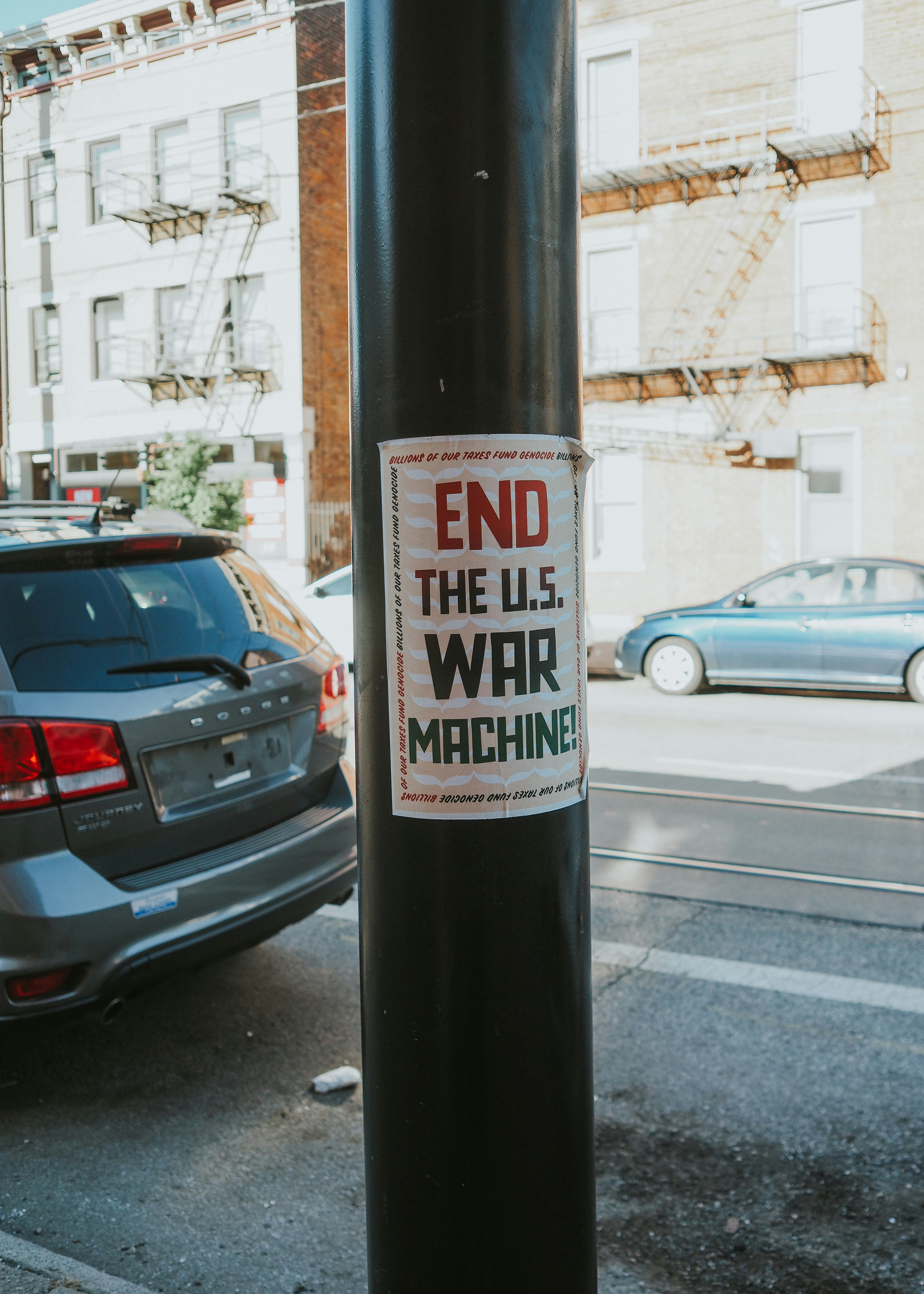A sticker on a pole on a city street photo – Free Grey Image on Unsplash