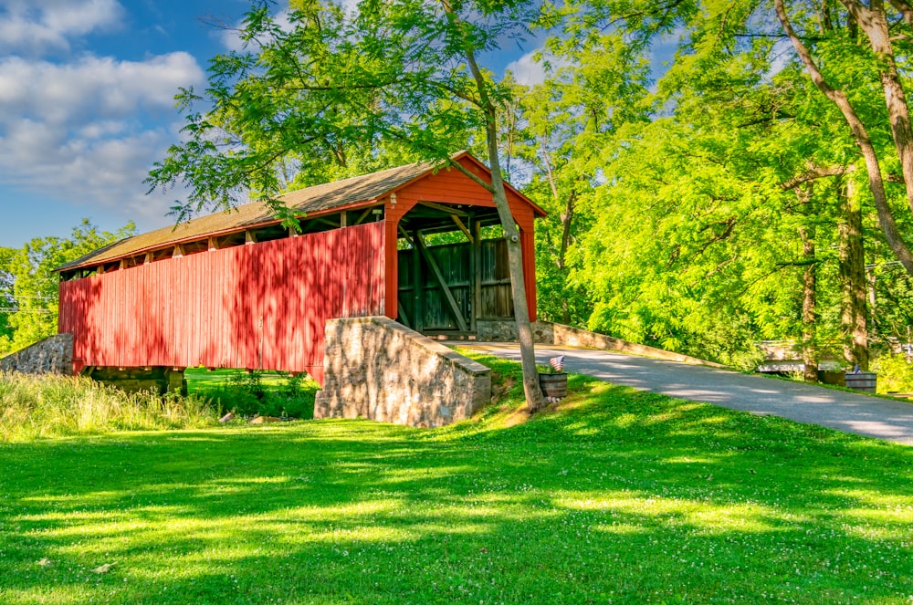 a red covered bridge over a small stream