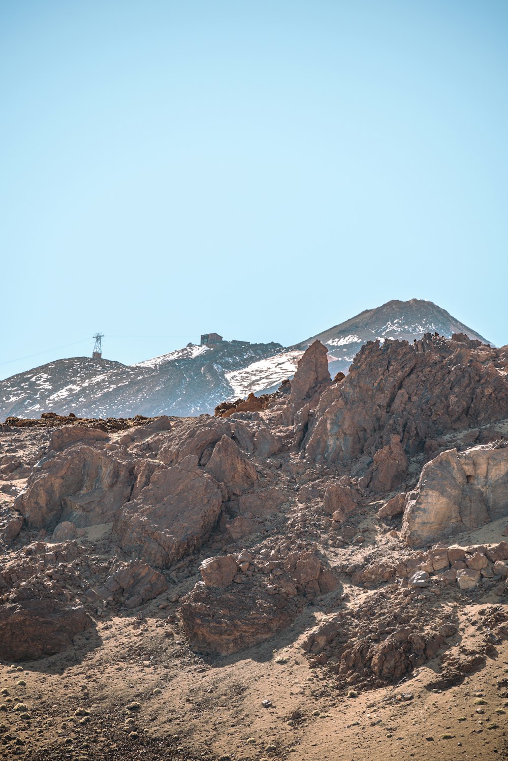 a mountain covered in snow and rocks under a blue sky