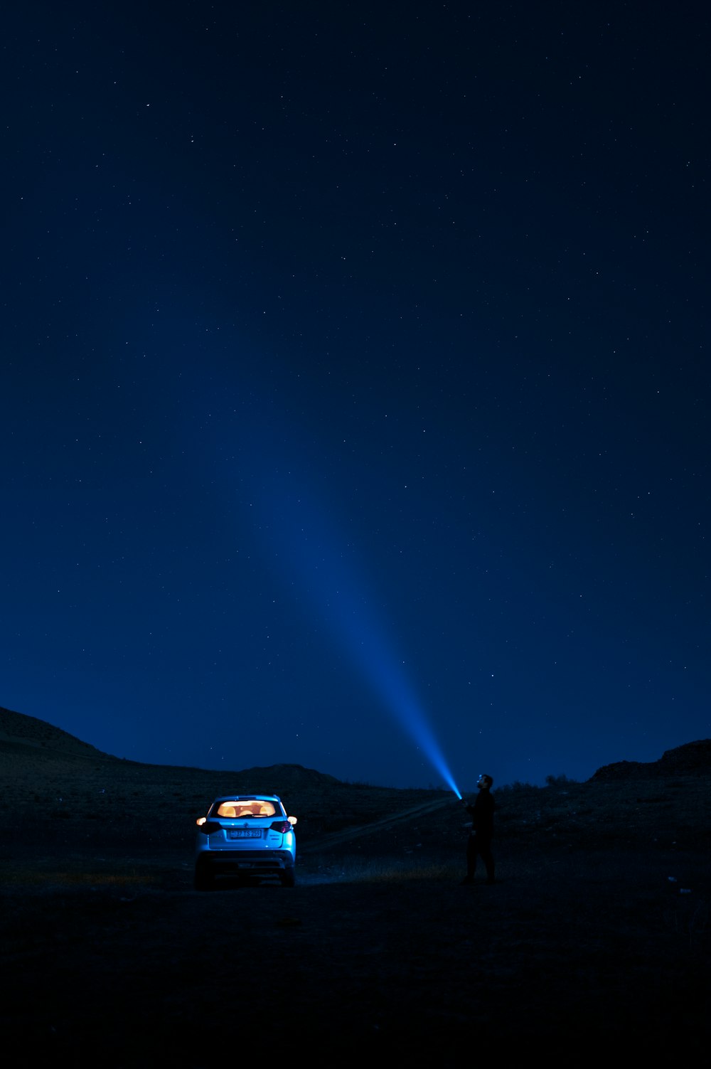 a car parked in the middle of a field at night