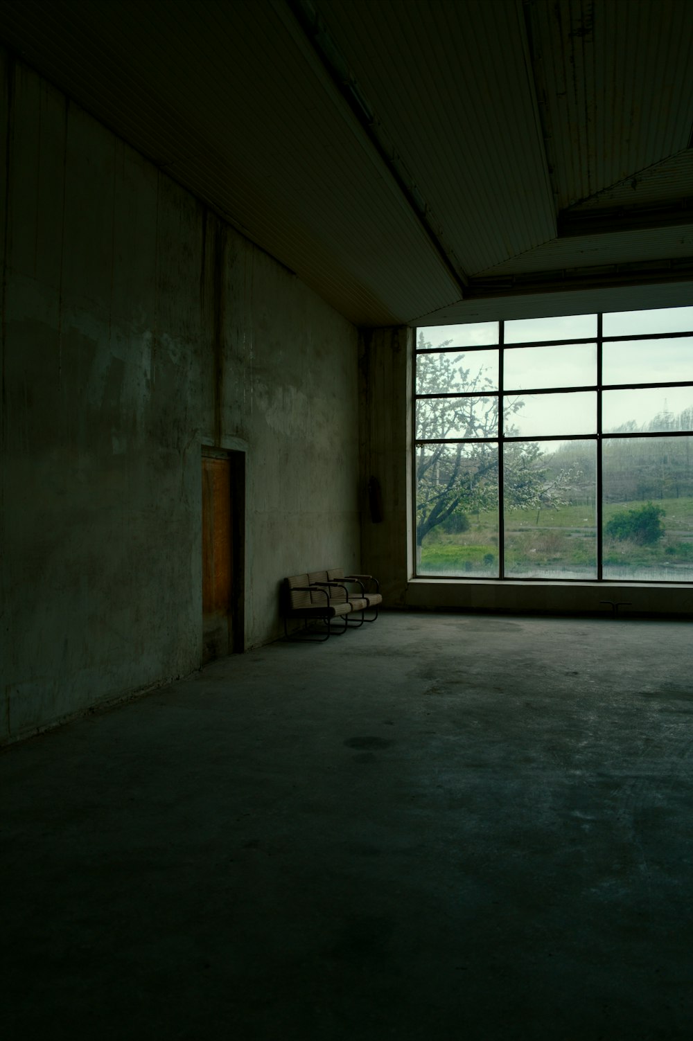 an empty room with a large window and a bench