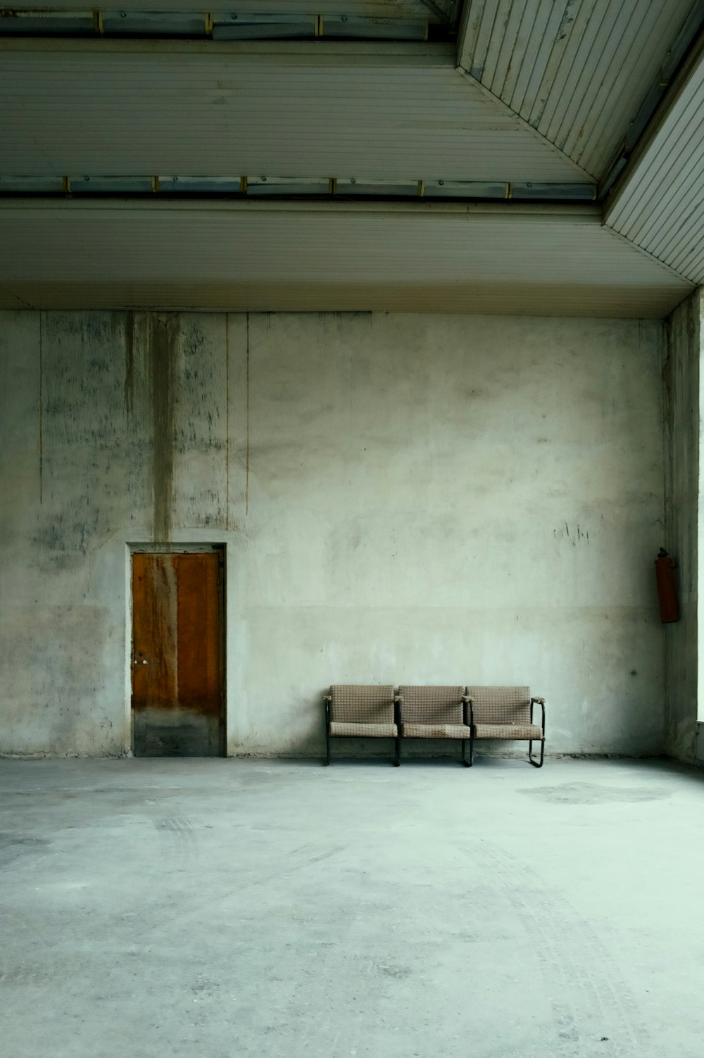 an empty room with a bench and a door