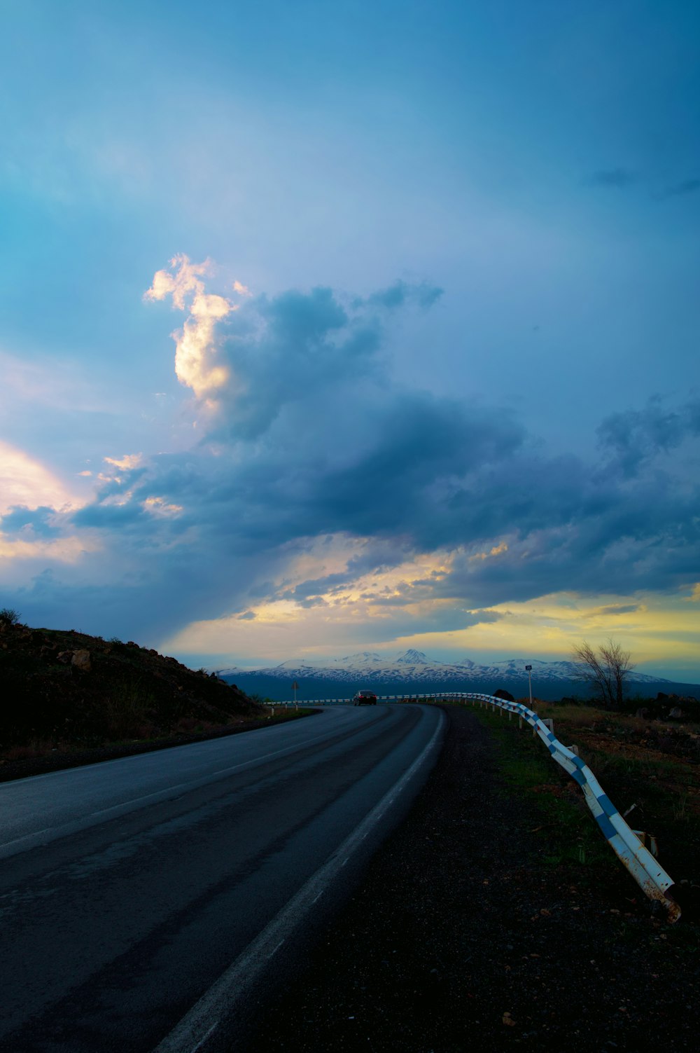 a long road with a sky filled with clouds