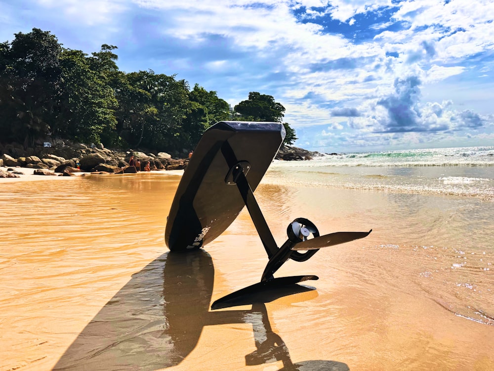 a surfboard sticking out of the sand on a beach