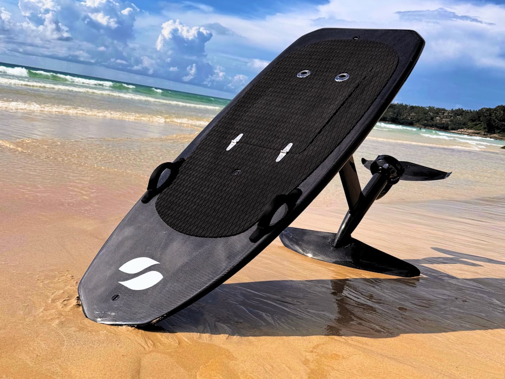 a surfboard sitting on top of a sandy beach