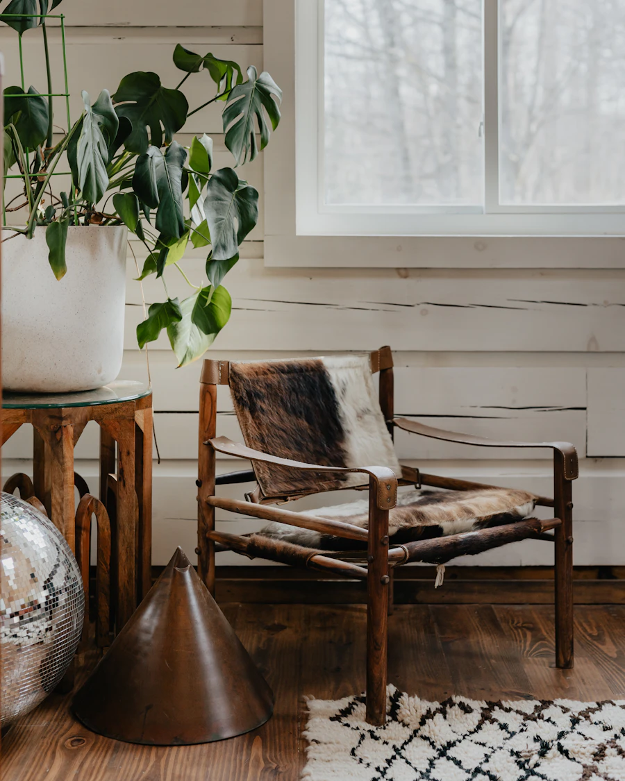 A vintage wooden armchair with a patterned seat and back, beside a leafy houseplant in a bright room. Illustrative stock photo, not a Claire’s Upholstery project.