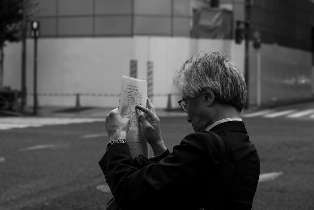 a man in a suit is reading a paper