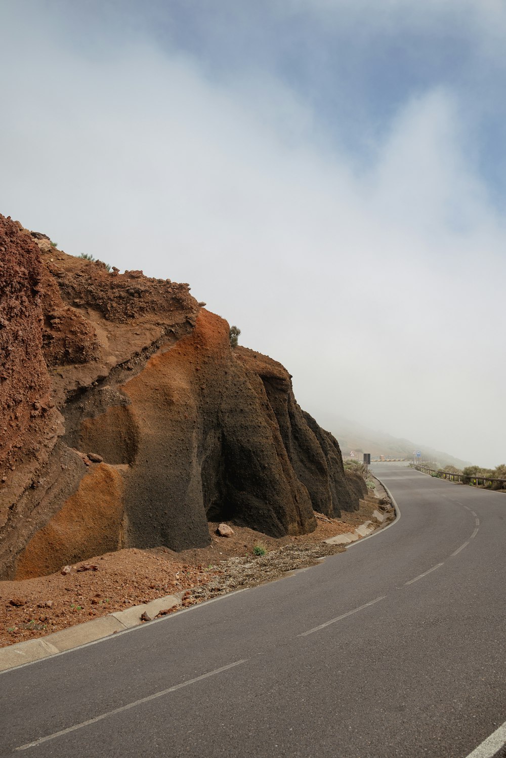 a curved road with a mountain in the background