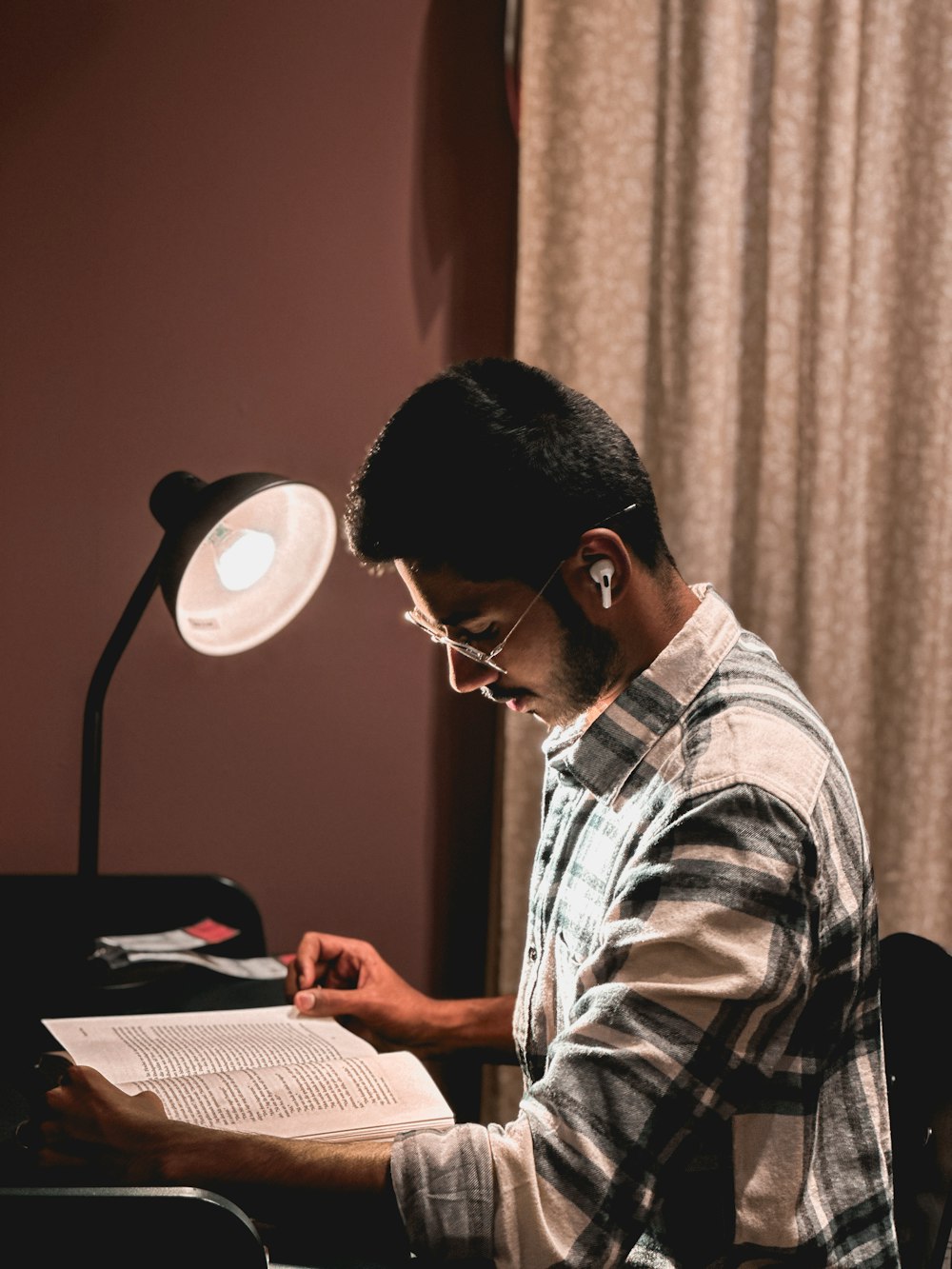 a man sitting at a desk writing on a piece of paper