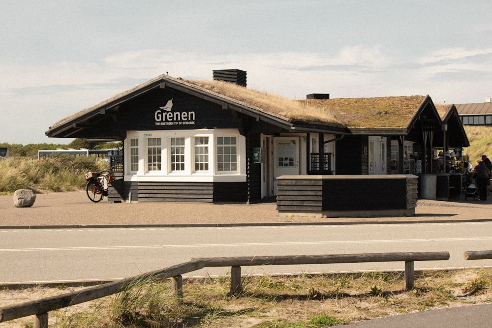 a black and white building with a grass roof