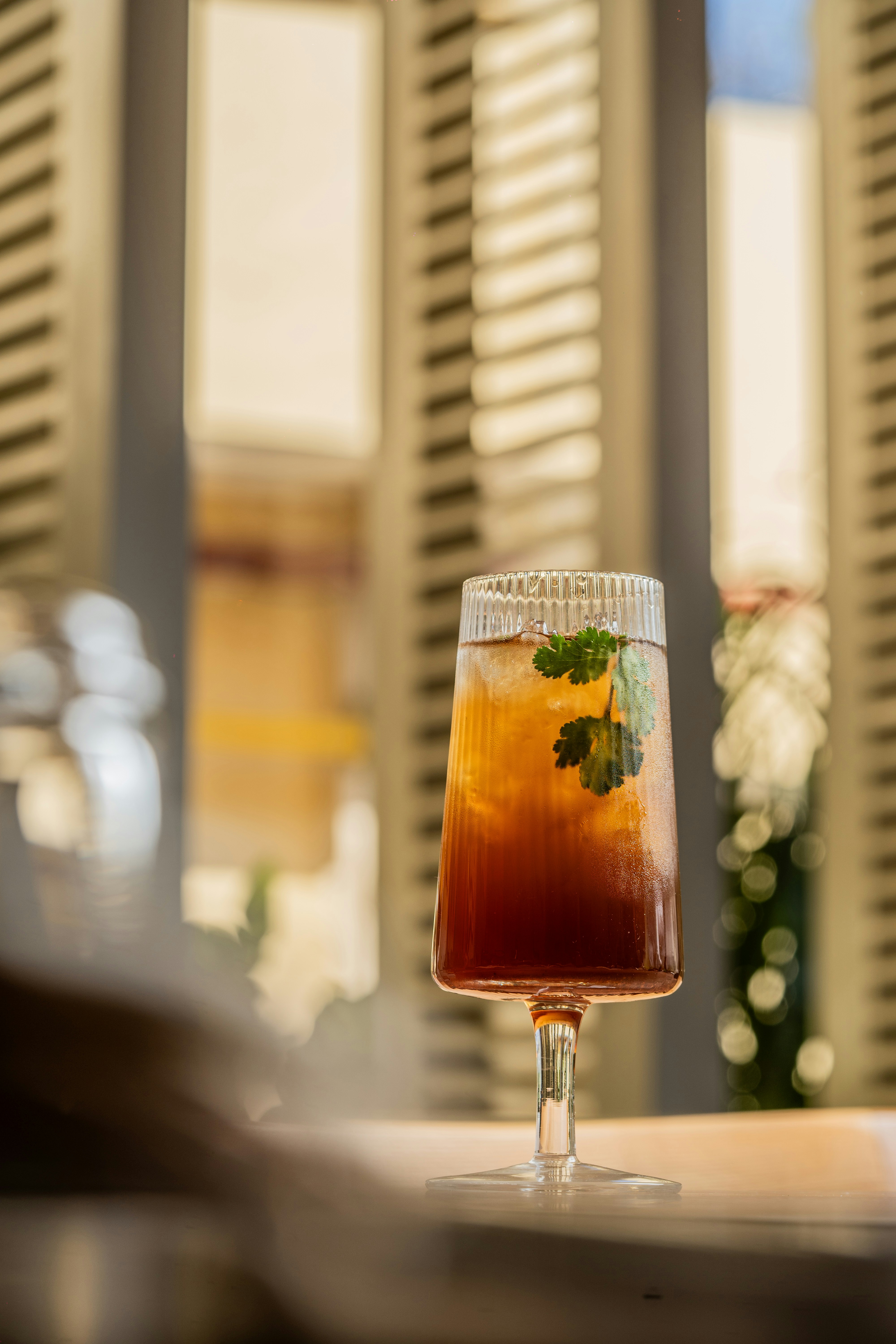 a drink sitting on top of a table next to a window