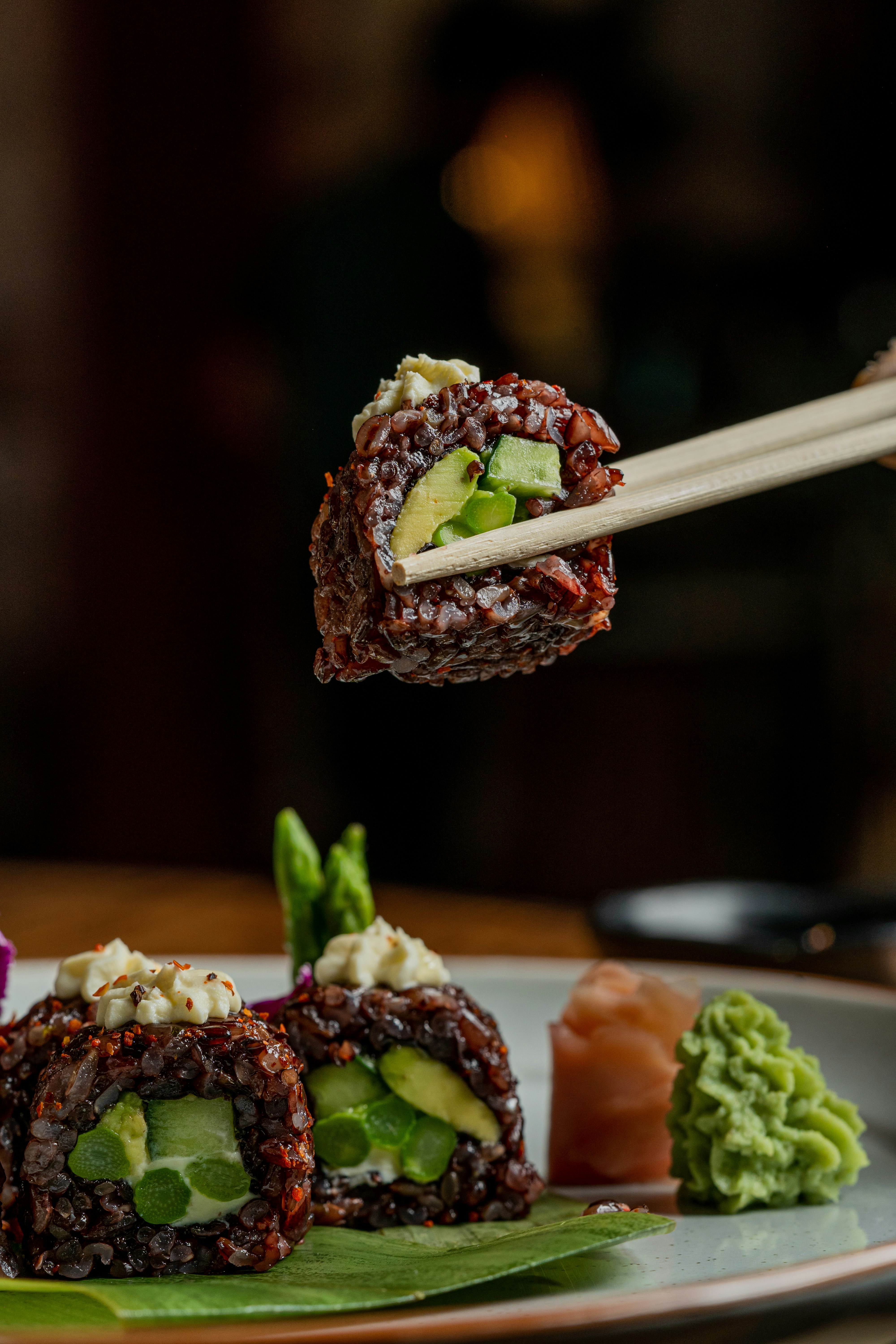 a plate of sushi with chopsticks sticking out of it