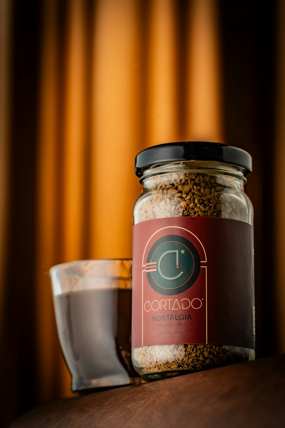 a jar of food sitting on a table next to a glass