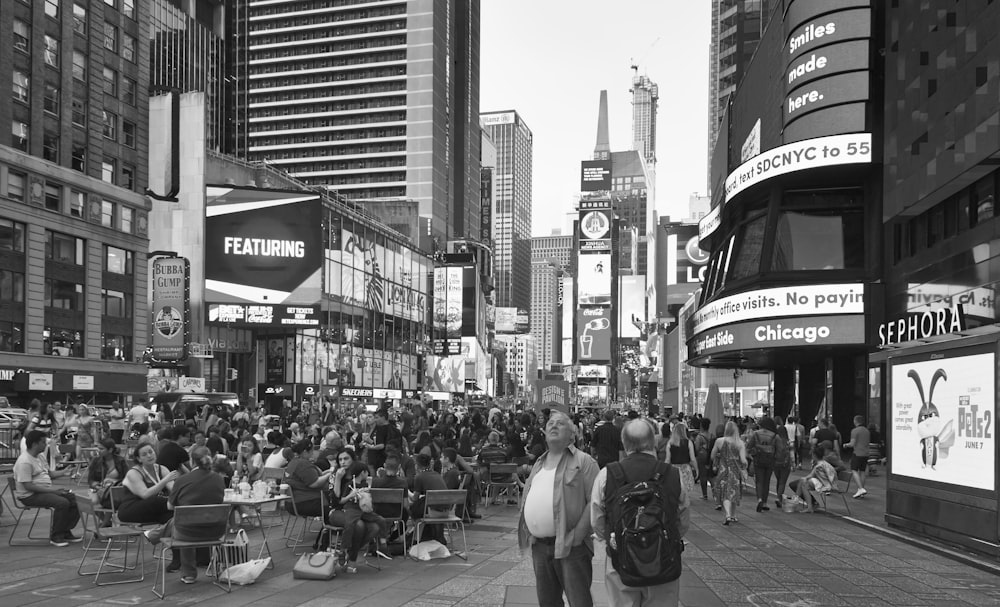 a crowd of people walking down a street next to tall buildings