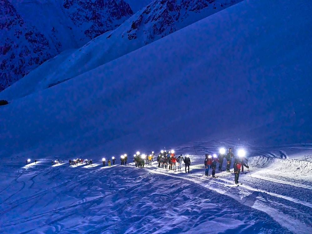 a group of people walking down a snow covered slope