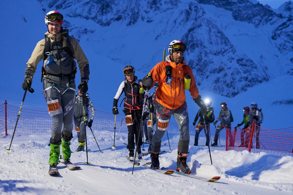 a group of people riding skis down a snow covered slope