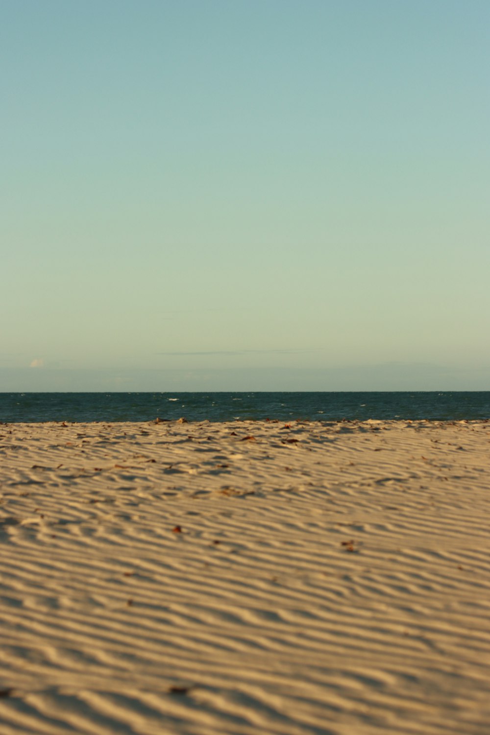 a person riding a surfboard on top of a sandy beach