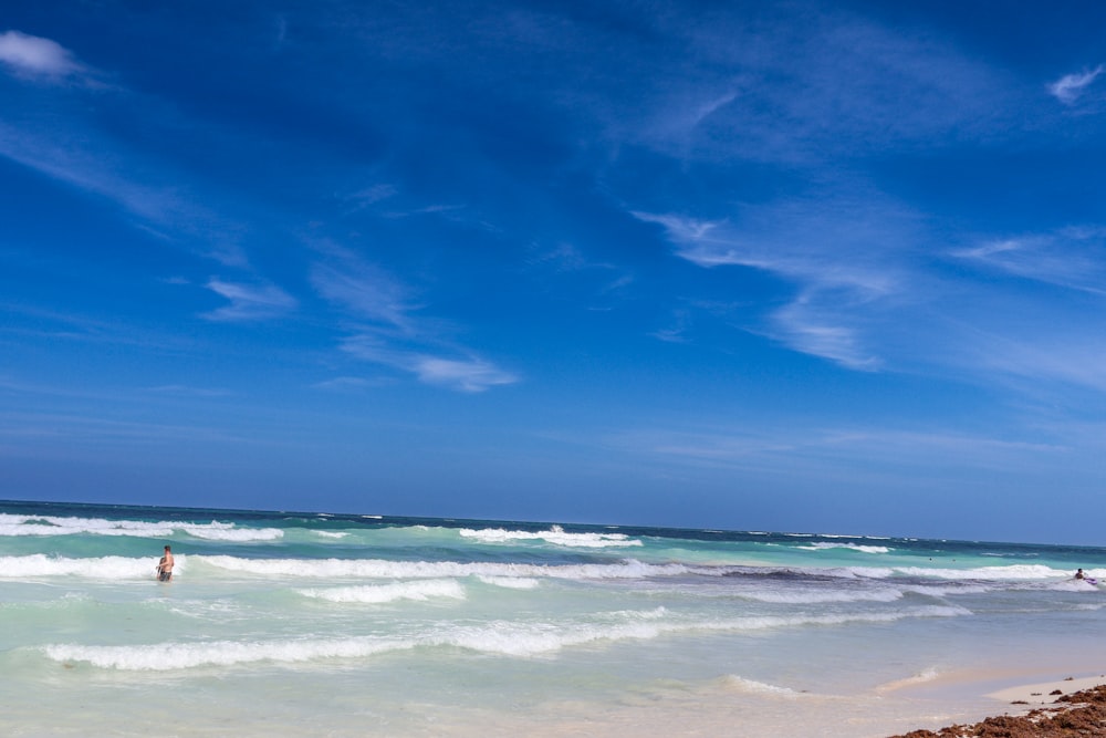 a person standing in the ocean with a surfboard