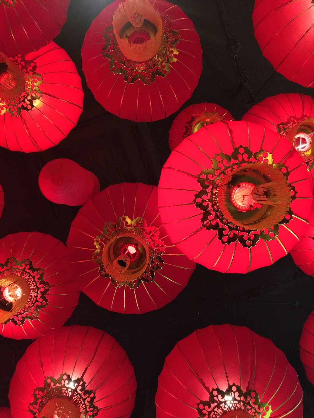 a group of red paper lanterns hanging from a ceiling