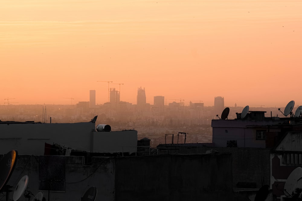 a view of a city from a rooftop at sunset