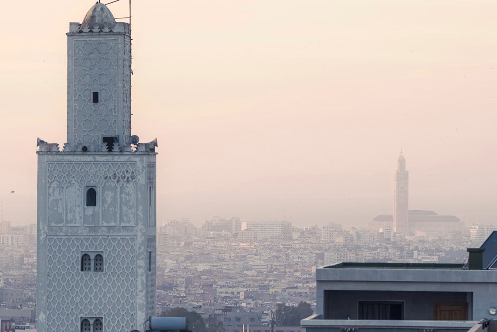 a tall white clock tower towering over a city