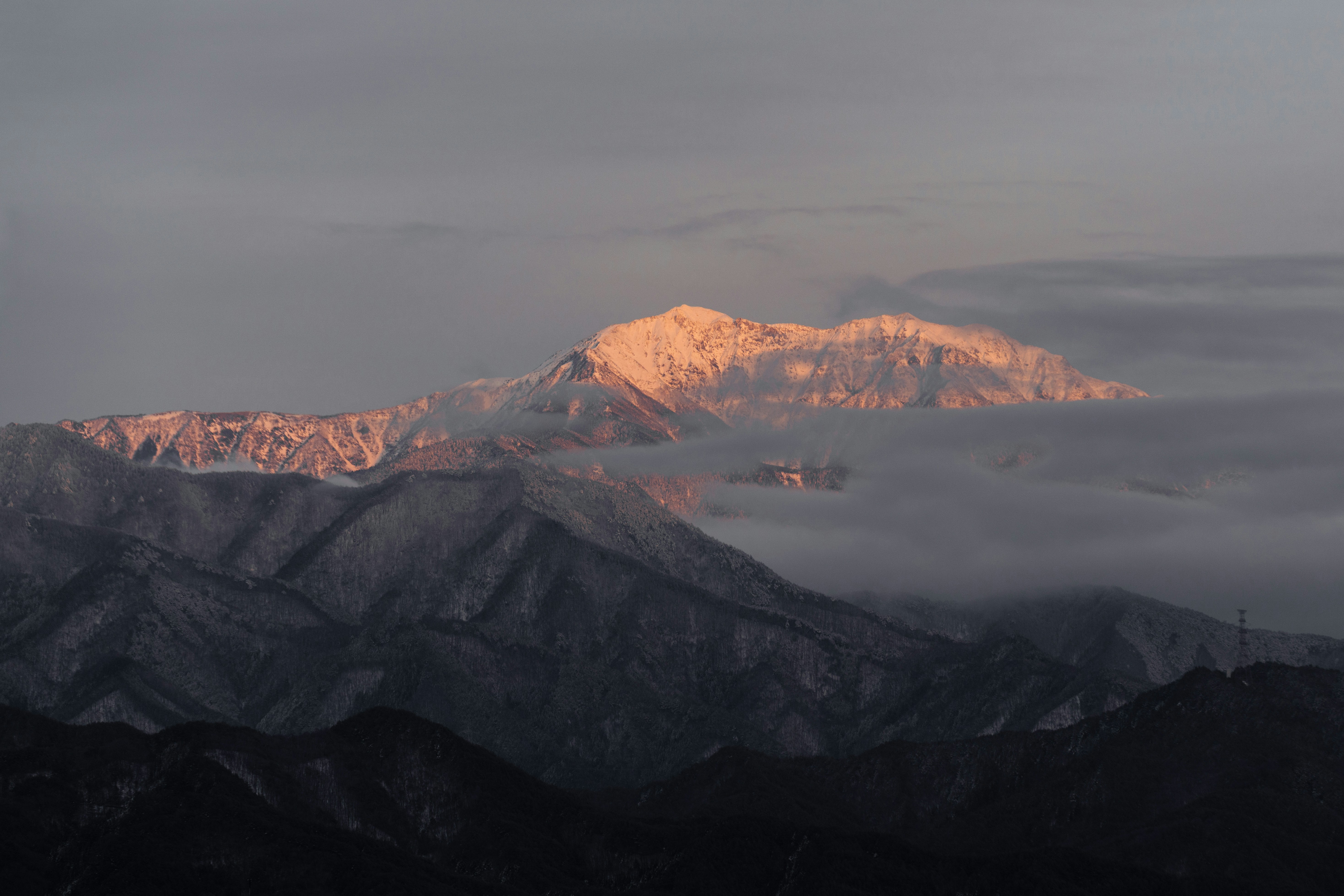 a view of a mountain range with clouds in the foreground