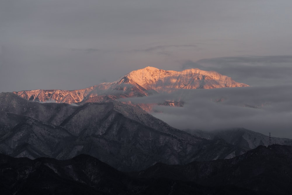 a view of a mountain range with clouds in the foreground