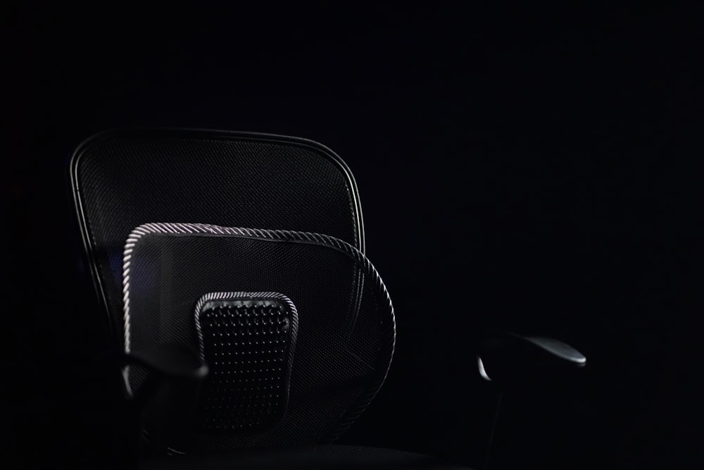 a black office chair sitting in the dark