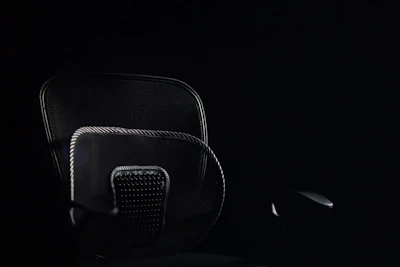 a black office chair sitting in the dark